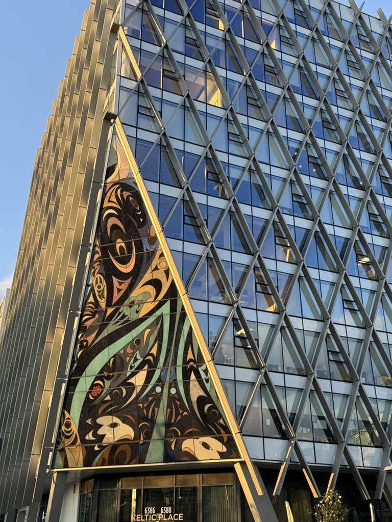 Glass building with triangular windows and coast salish art